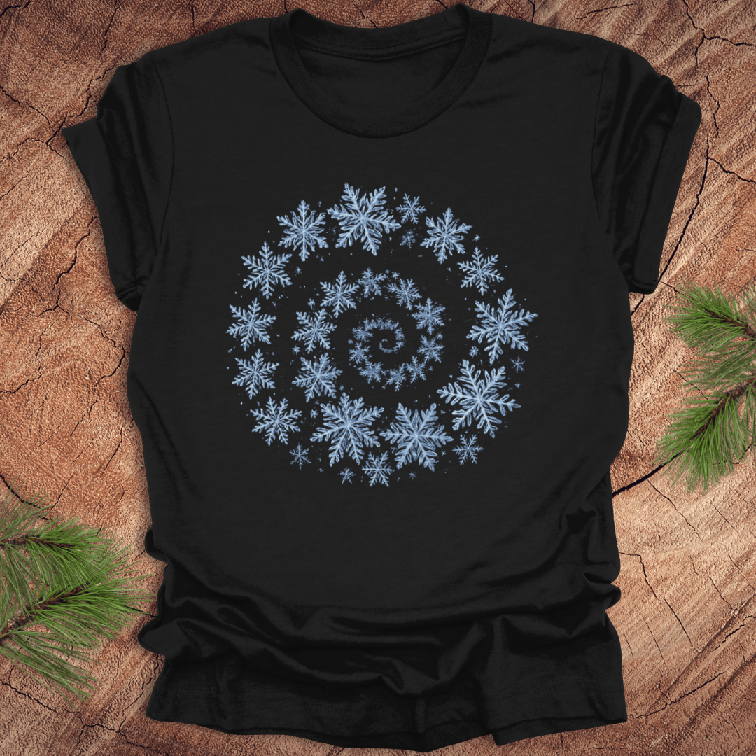 Black t-shirt with a spiral pattern of snowflakes on a wooden surface.