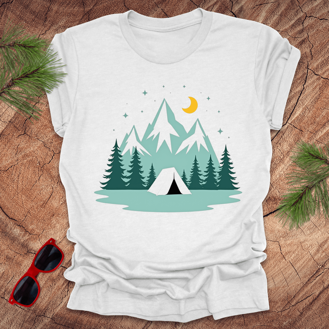 A white t-shirt with a graphic print of mountains, trees, a tent, moon, and stars.