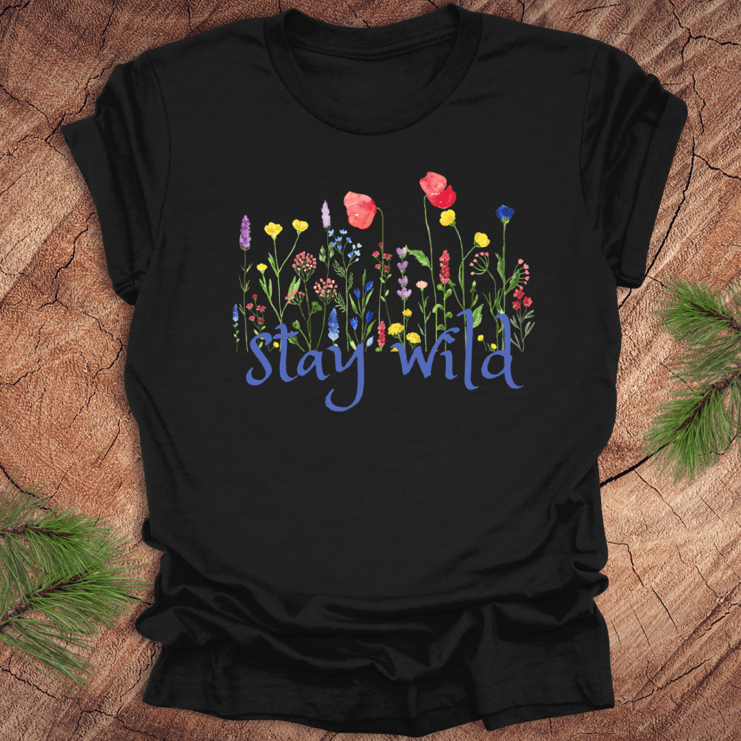 Black tshirt with the text, 'stay wild' with wildflowers on a wooden background.