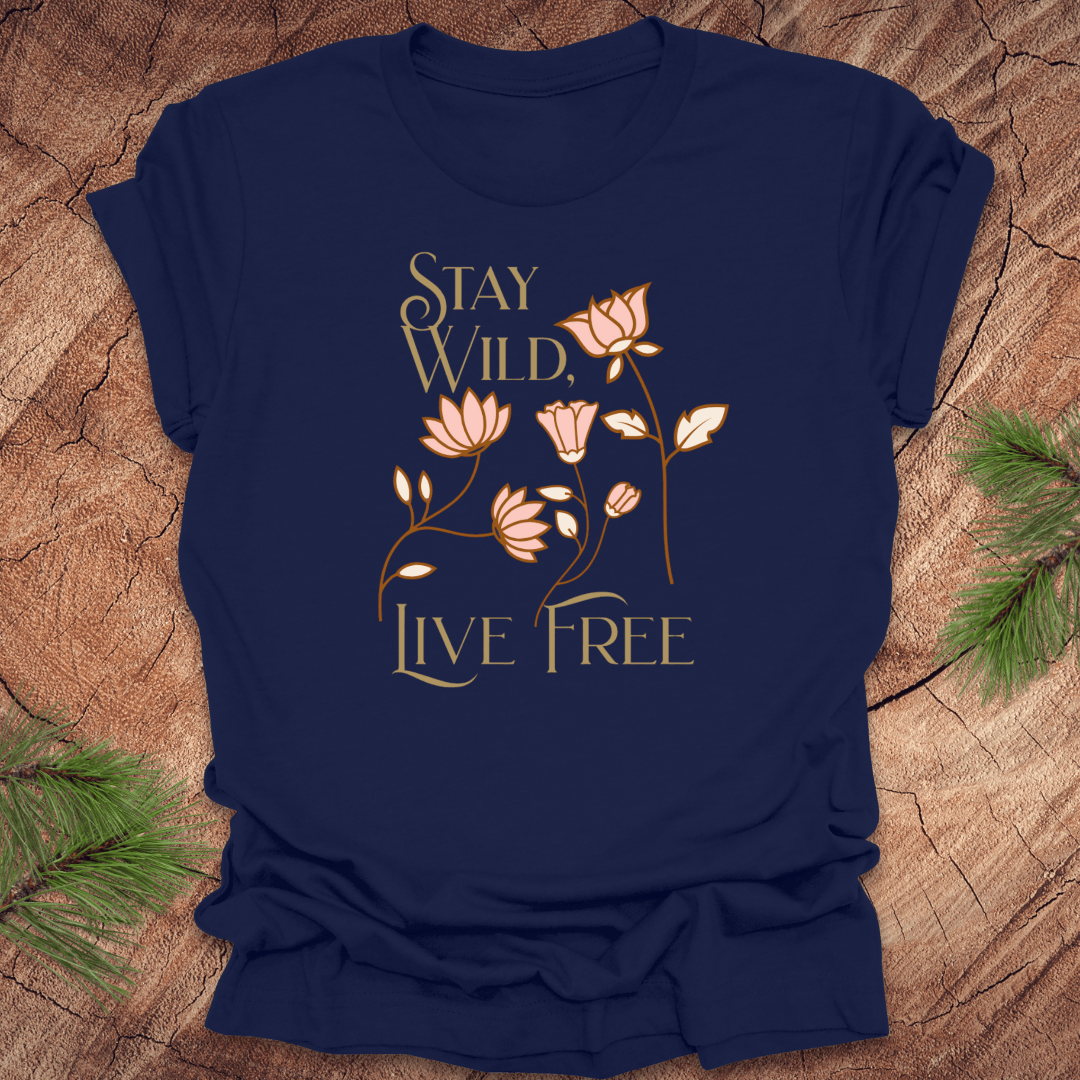 Navy blue t-shirt with floral design and text 'Stay Wild, Live Free' on a wooden surface.