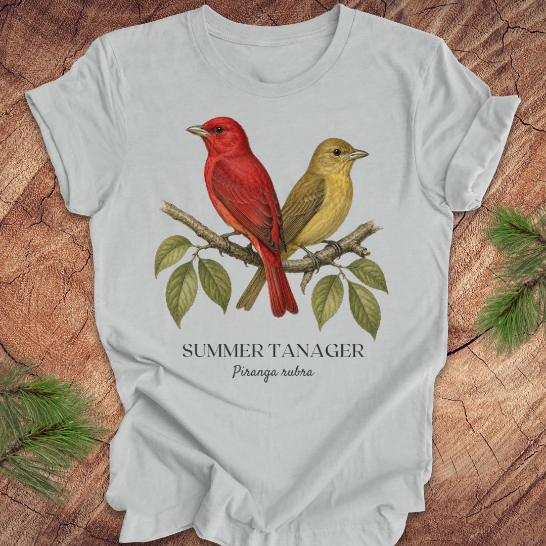 Gray t-shirt with male and female summer tanager bird illustration on a wooden surface