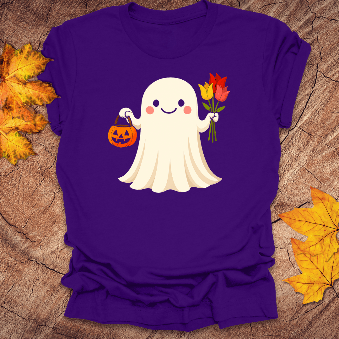 Purple t-shirt with a cartoon ghost holding flowers and a pumpkin on a wooden surface with fall leaves.