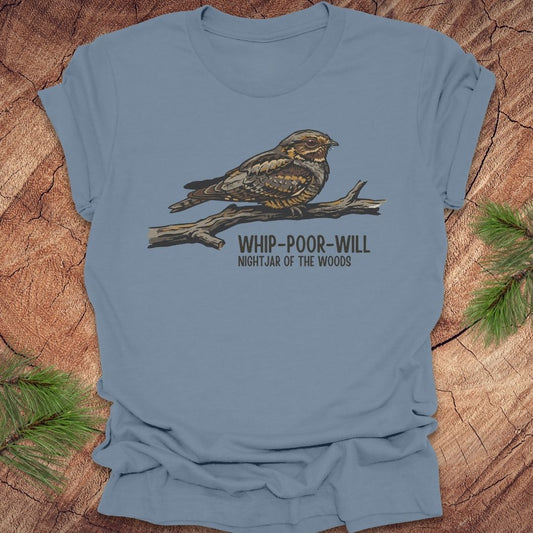Steel blue t-shirt with a whip-poor-will bird on a branch with text 'nightjar of the woods' on a wood background.