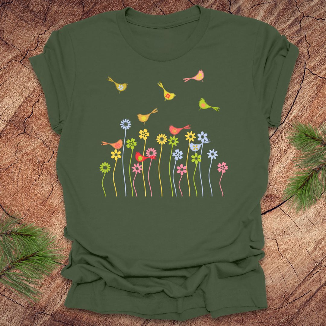 Green t-shirt with colorful bird and flower design on a wooden surface