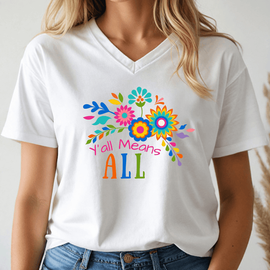 Person wearing a white v-neck t-shirt with colorful floral design and text, 'Y'all Means All'.