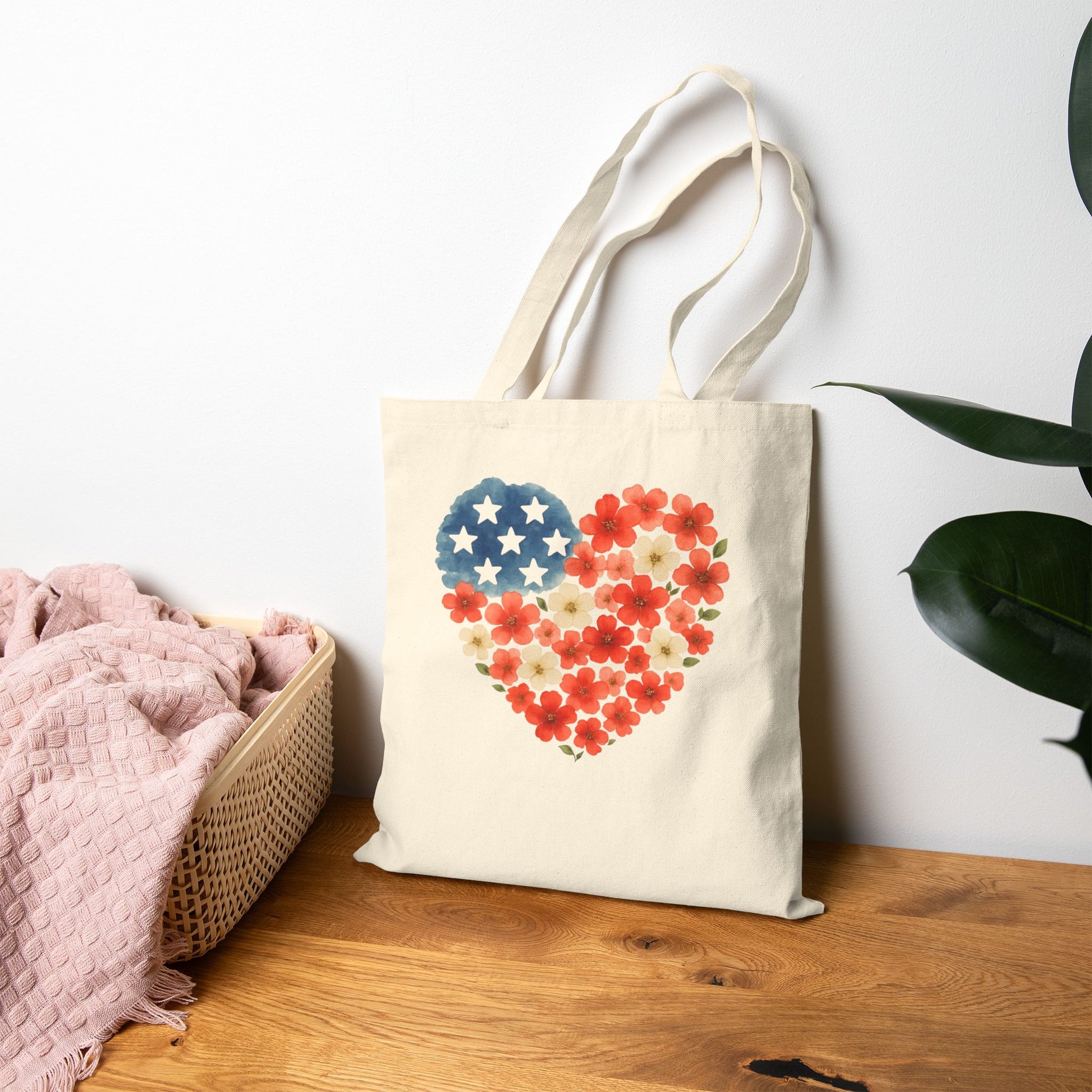 Tote bag with heart-shaped American flag design on a wooden surface with a white wall background
