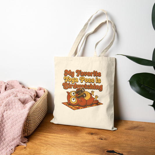Tote bag with owl design and text on a wooden surface with a white wall background