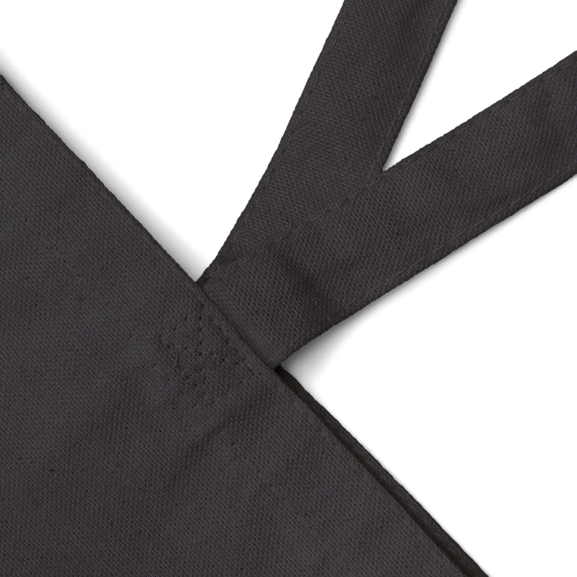 Black canvas tote bag fabric with a subtle pattern on a white background