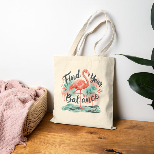 Tote bag with flamingo design and 'Find Your Balance' text on a wooden surface.