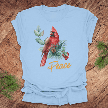 Light blue t-shirt with a red cardinal and 'Peace' text on a wooden surface