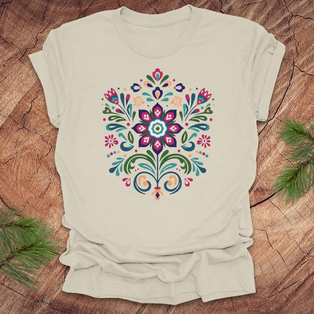 Beige t-shirt with a colorful dutch inspired floral design on a wood background.