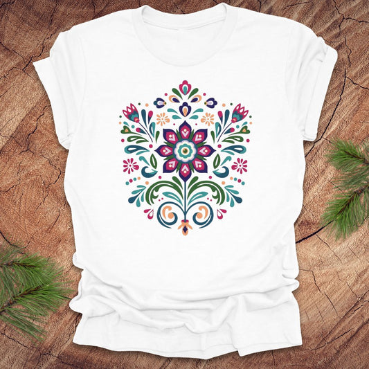 White t-shirt with a colorful dutch inspired floral design on a wood background.