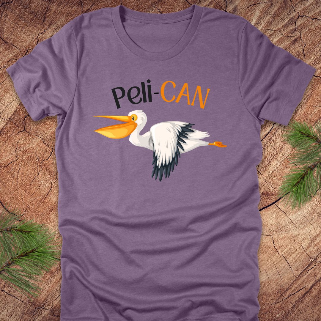 Purple t-shirt with a pelican graphic and 'Peli-CAN' text on a wooden surface.