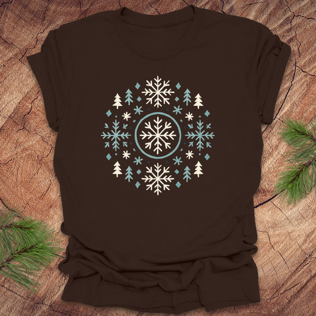 Brown t-shirt with snowflake and tree design on a wooden surface