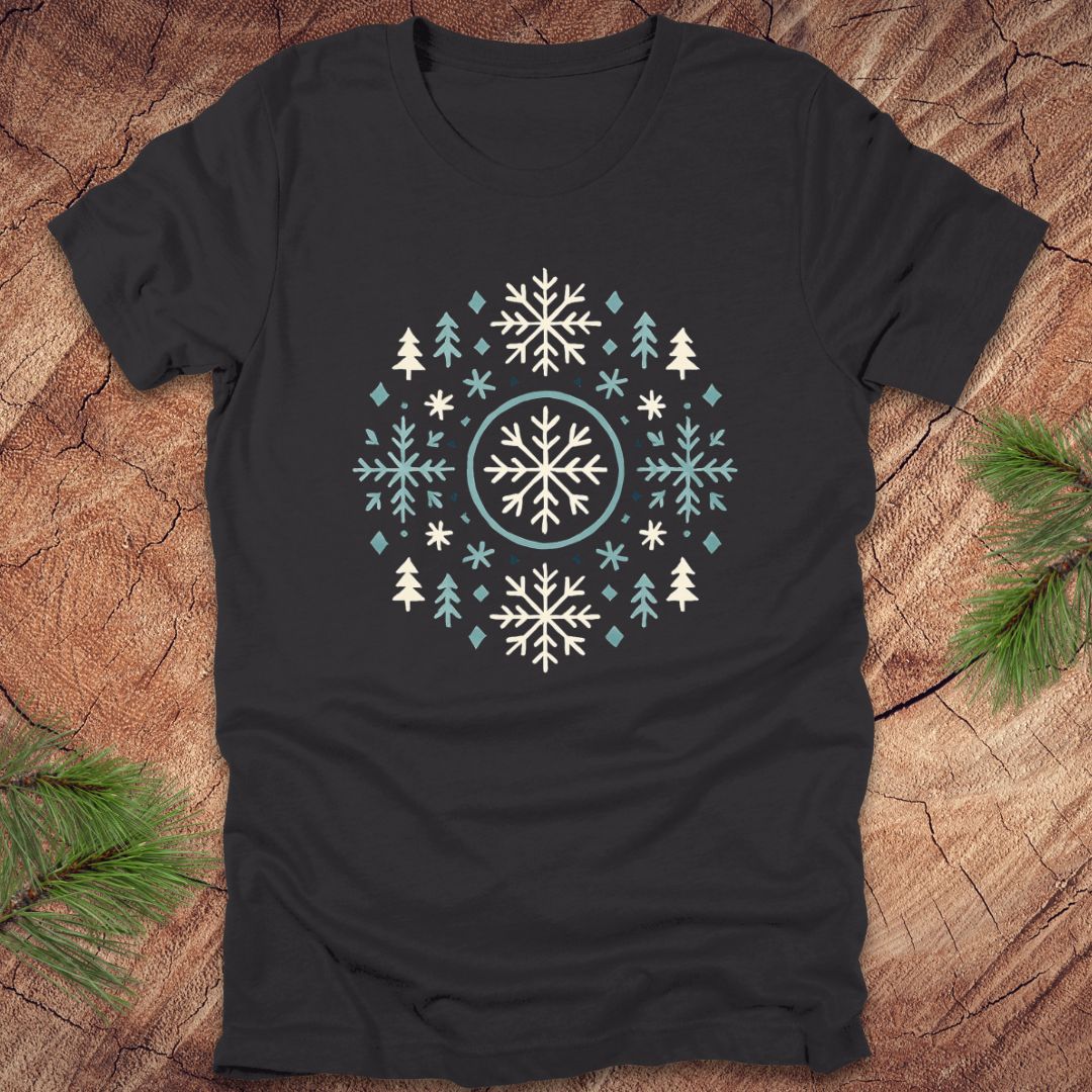Black t-shirt with snowflake and tree design on a wooden surface