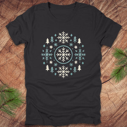 Black t-shirt with snowflake and tree design on a wooden surface