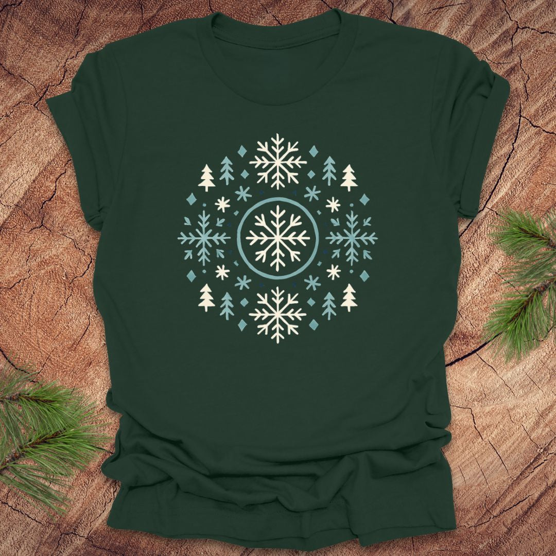 Green t-shirt with snowflake and tree design on a wooden surface