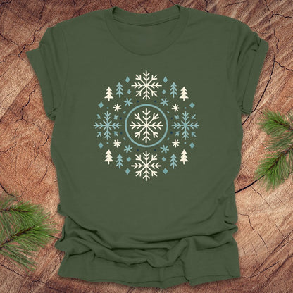 Green t-shirt with snowflake and tree design on a wooden surface