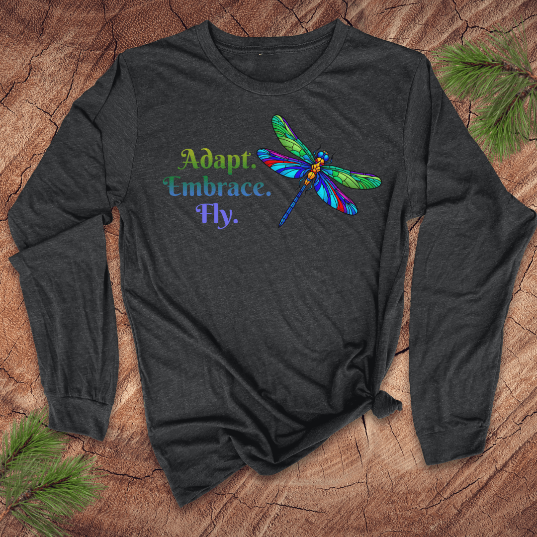 Dark long-sleeve shirt with a colorful dragonfly design and text on a wooden surface.