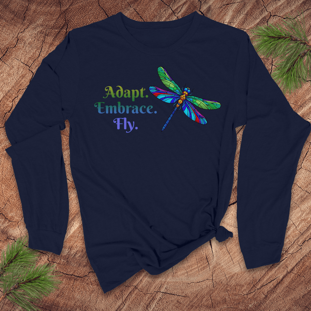 Navy blue long-sleeve tshirt with colorful dragonfly design and text on a wooden surface.