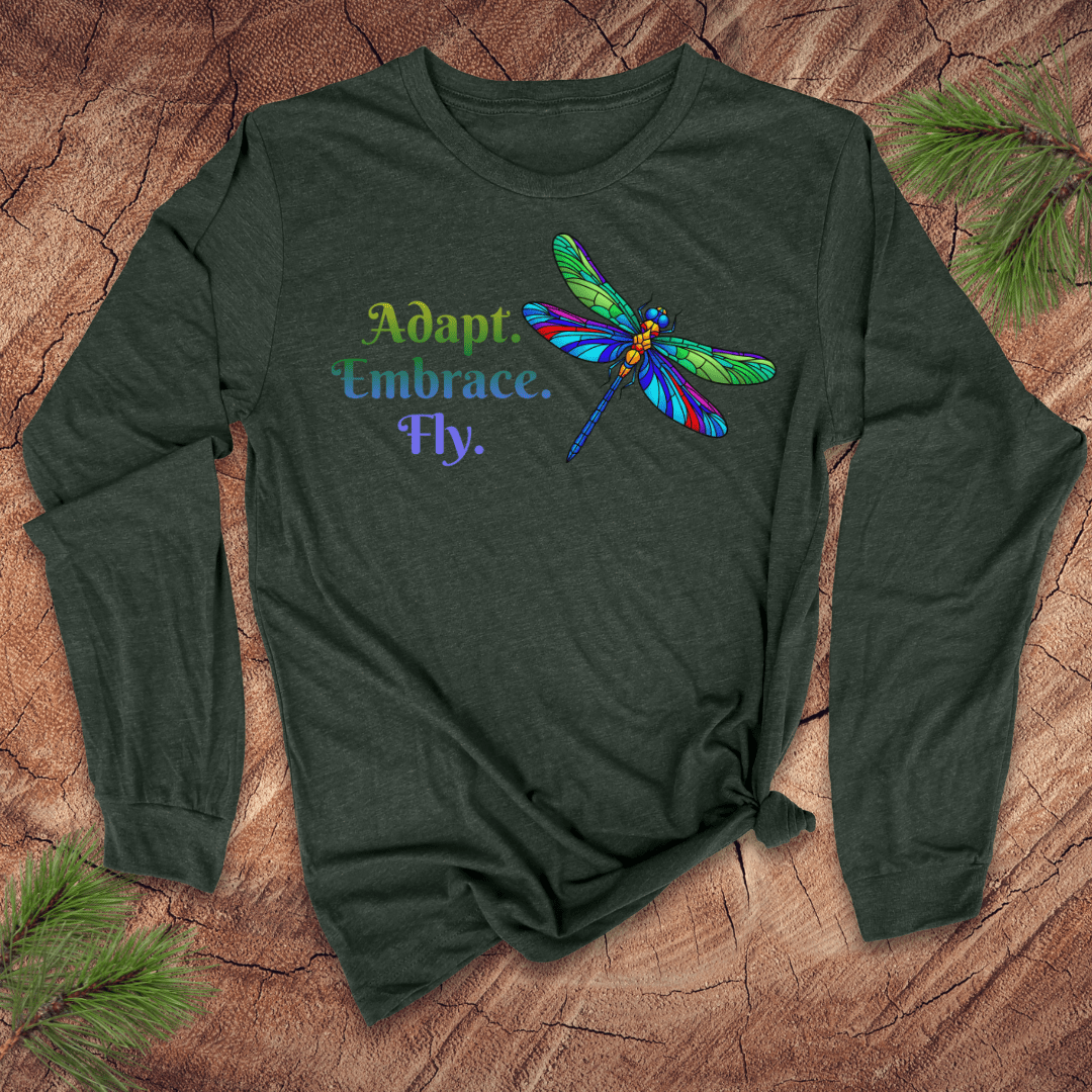 Green long-sleeve shirt with colorful dragonfly design and text on a wooden surface.