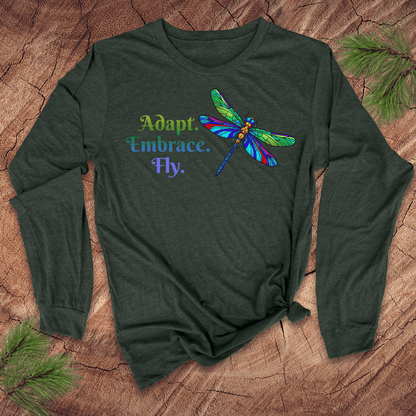 Green long-sleeve shirt with colorful dragonfly design and text on a wooden surface.