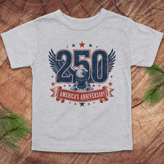 Gray t-shirt with '250 America's Anniversary' design on a wooden surface