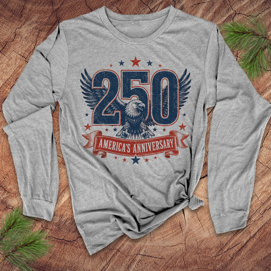 Gray long-sleeve shirt with '250 America's Anniversary' design on a wooden surface.