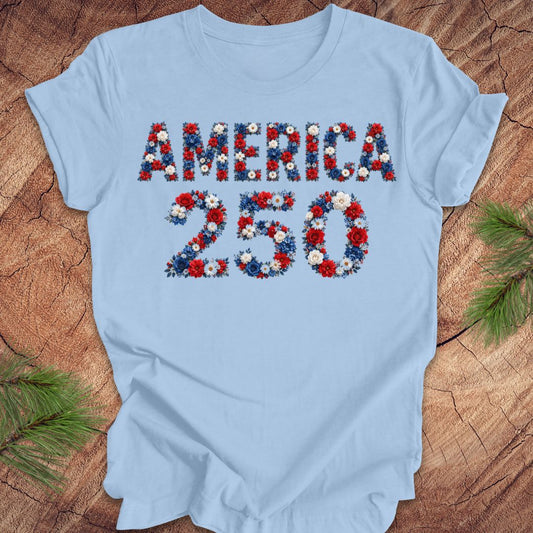 Light blue t-shirt with 'AMERICA 250' design featuring flowers on a wooden surface.
