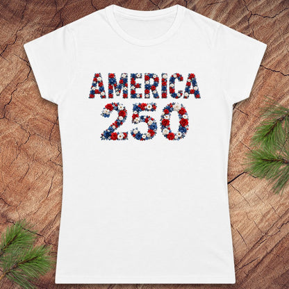 White t-shirt with 'AMERICA 250' printed in red, blue, and white on a wooden surface.
