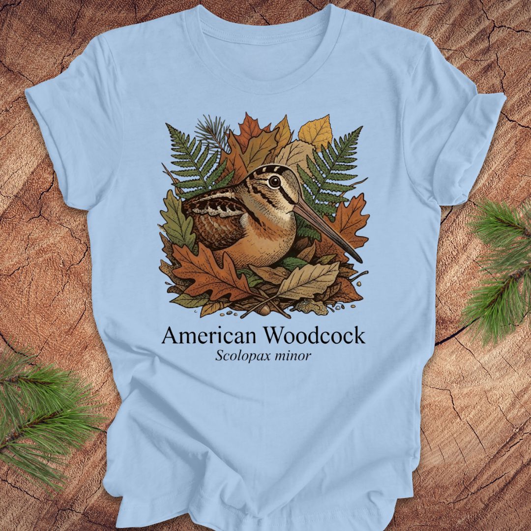 Light blue t-shirt with American Woodcock design on a wooden surface