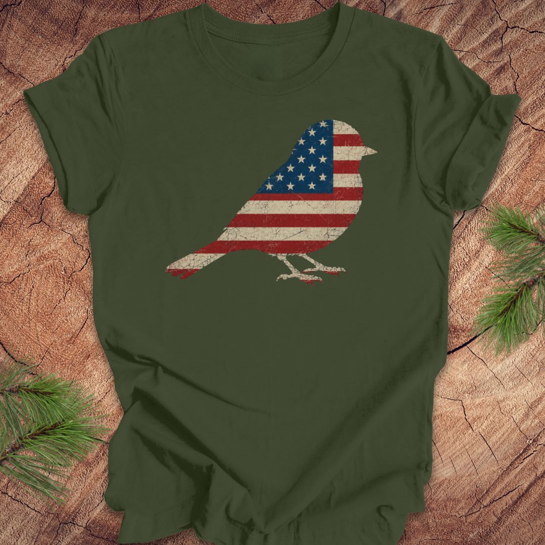 Green t-shirt with a bird-shaped American flag design on a wooden surface.