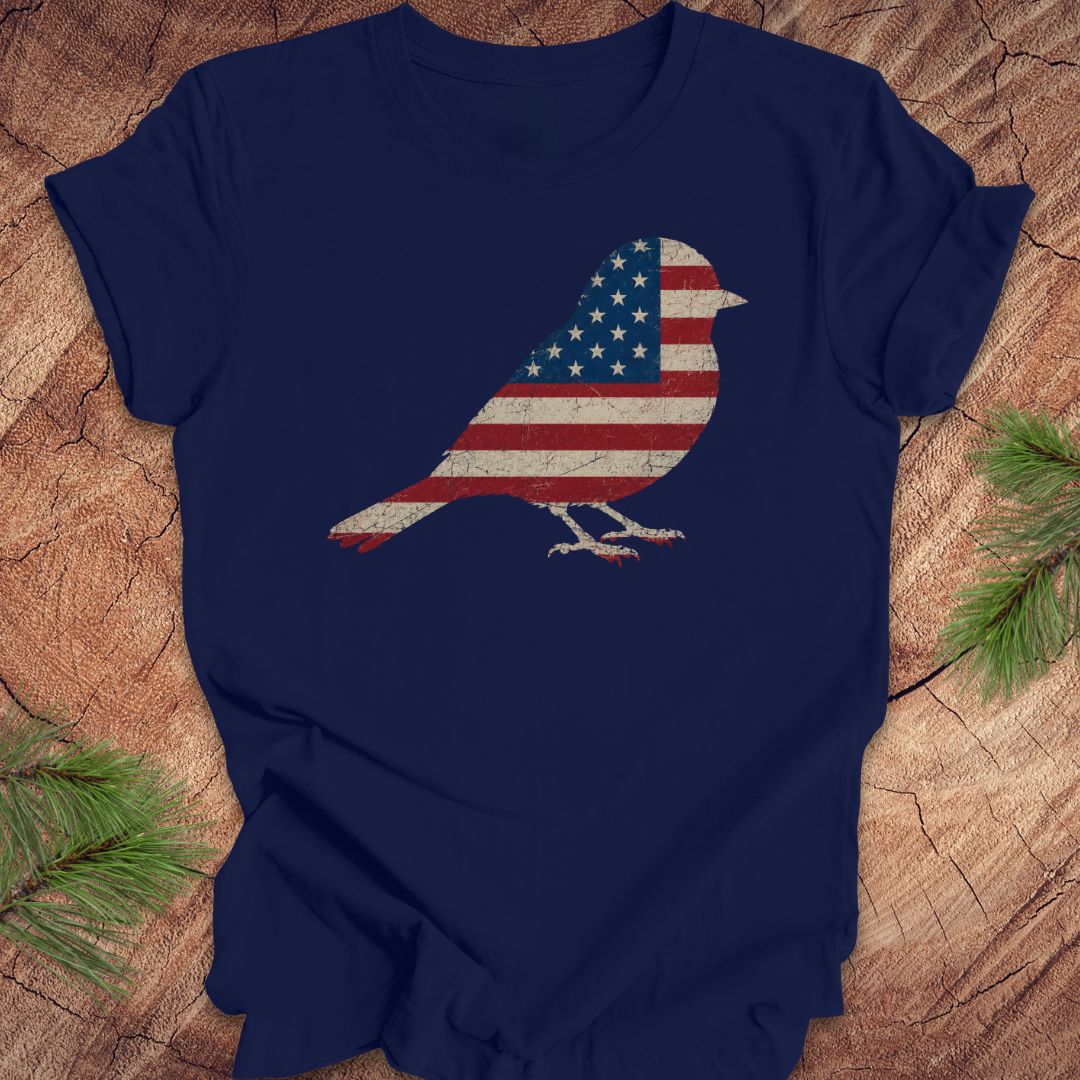 Navy blue t-shirt with an American flag bird design on a wooden surface.