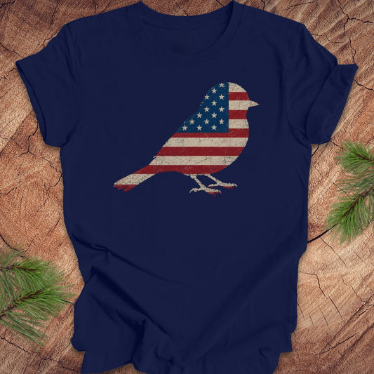 Navy blue t-shirt with an American flag bird design on a wooden surface.