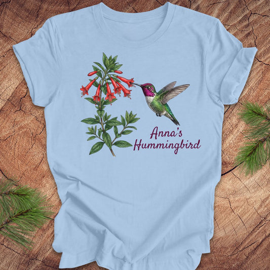 Light blue t-shirt with Anna's Hummingbird design on a wooden surface