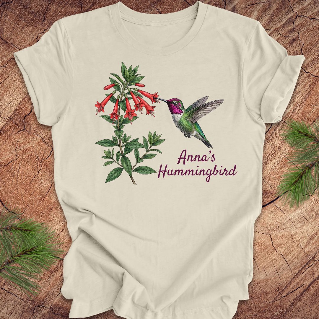 Beige t-shirt with Anna's Hummingbird design on a wooden surface