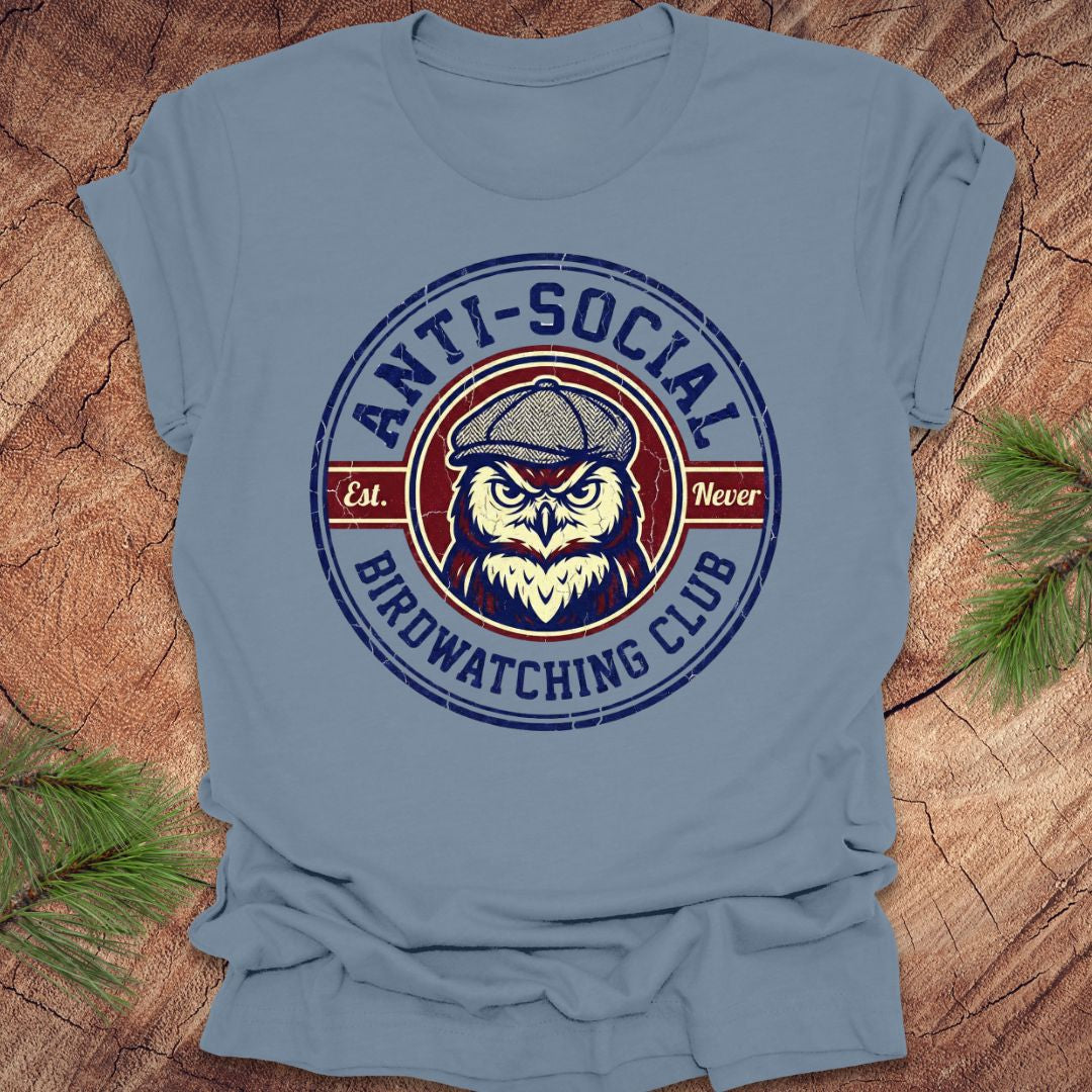 Blue t-shirt with an owl graphic and text 'Anti-Social Birdwatching Club' on a wooden surface.
