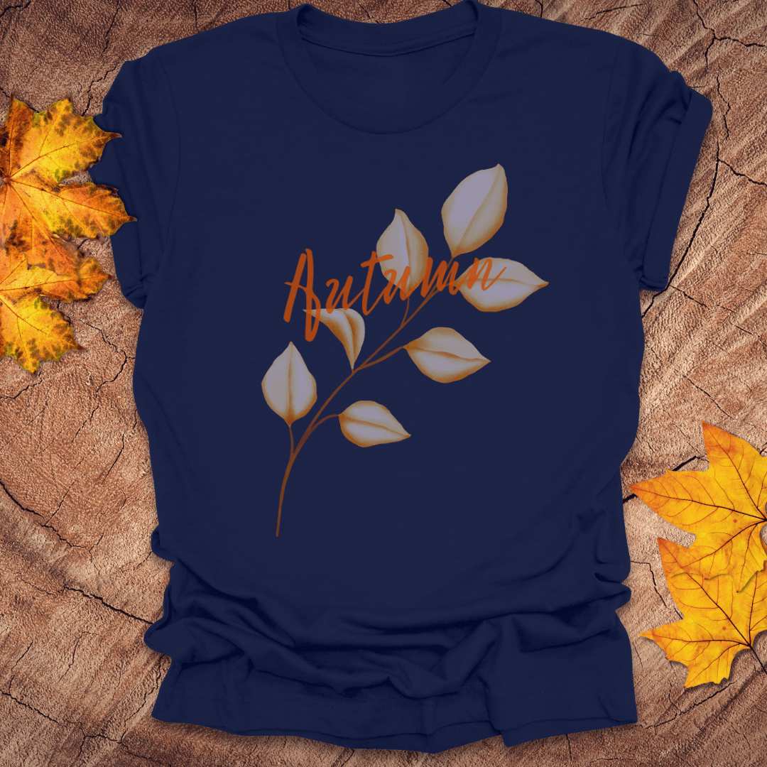Navy blue t-shirt with 'Autumn' and leaf design on a wooden surface with fall leaves.
