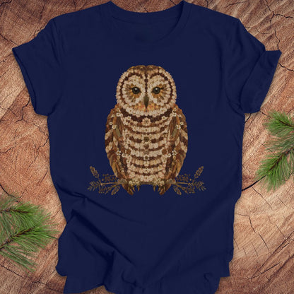 Navy blue t-shirt with an owl and flower design on a wooden surface