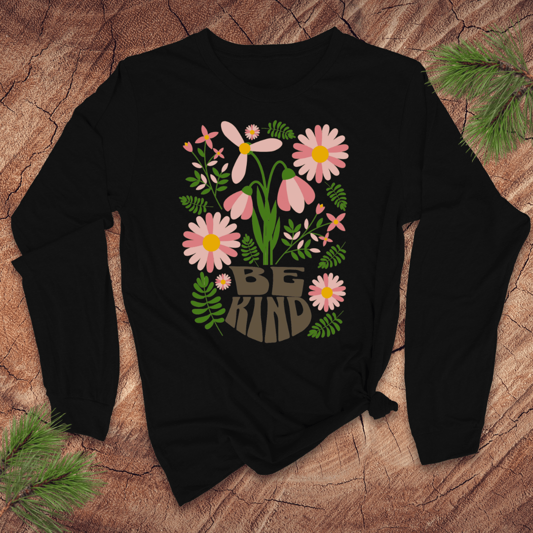 Black long sleeve tshirt with floral design and 'Be Kind' text on a wooden surface
