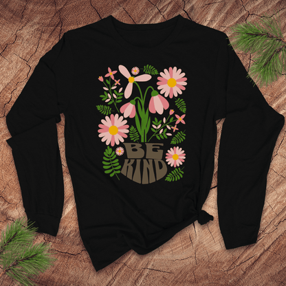 Black long sleeve tshirt with floral design and 'Be Kind' text on a wooden surface