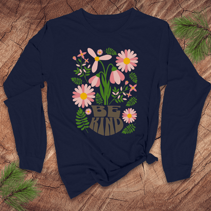 Navy blue long-sleeve shirt with floral design and 'Be Kind' text on a wooden surface.