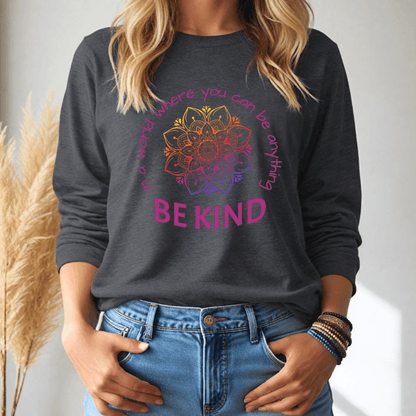 Person wearing a dark gray long sleeve tshirt with a colorful mandala design and text, standing against a neutral background.