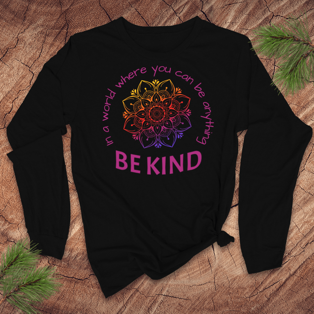 Black long-sleeve tshirt with a colorful mandala and 'Be Kind' text on a wooden surface