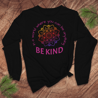 Black long-sleeve tshirt with a colorful mandala and 'Be Kind' text on a wooden surface