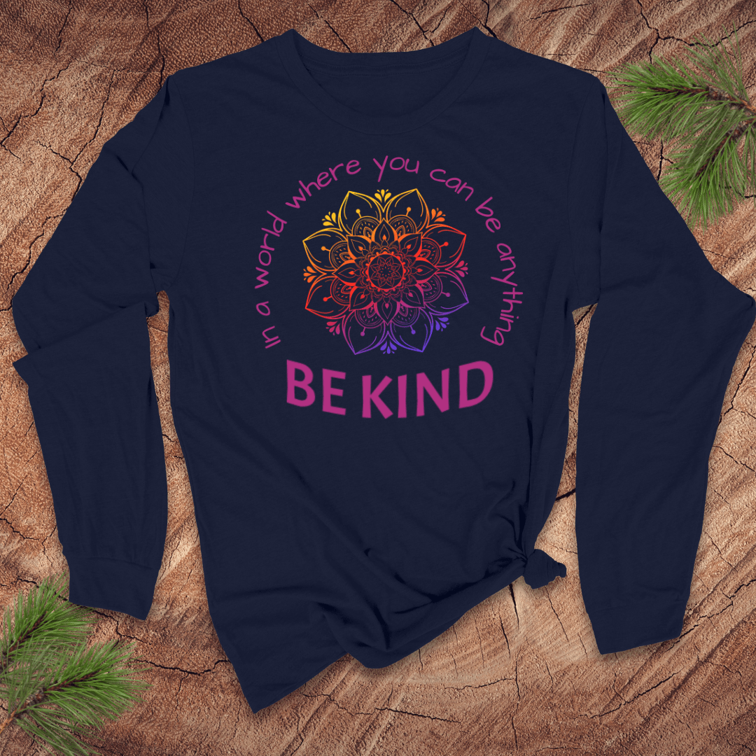 Navy blue long-sleeve shirt with a colorful mandala and 'Be Kind' text on a wooden surface.
