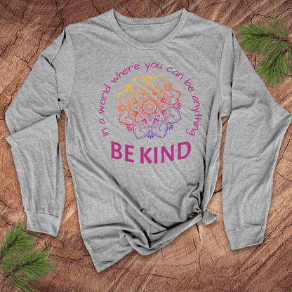 Gray long-sleeve shirt with a colorful mandala and 'Be Kind' text on a wooden surface.