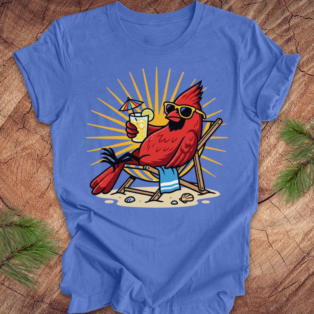 Blue t-shirt with a red cardinal wearing sunglasses and holding a drink on a wooden surface.