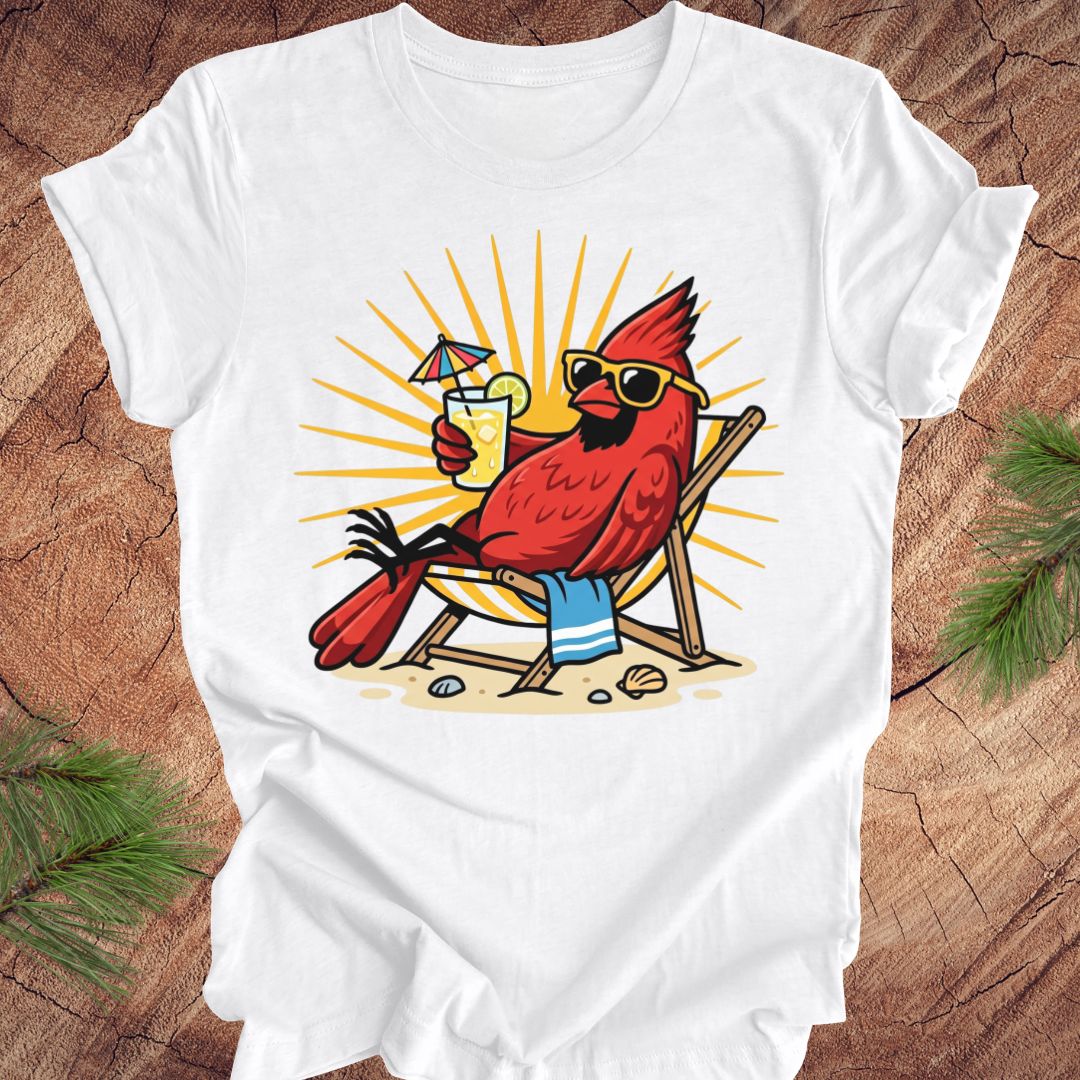 White t-shirt with a red cardinal wearing sunglasses and holding a drink on a wooden surface.