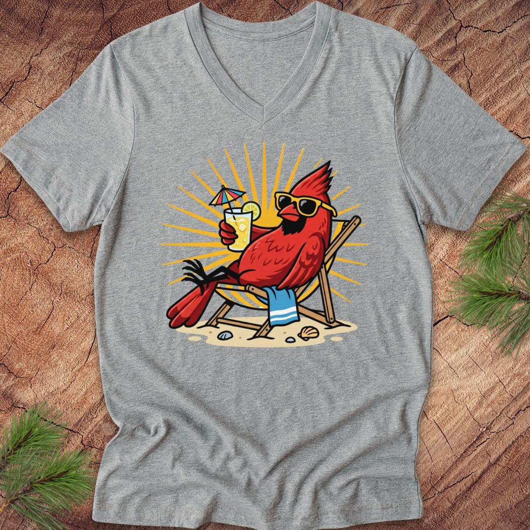 Gray t-shirt with a cardinal wearing sunglasses and a hat, holding a drink, on a wooden surface.